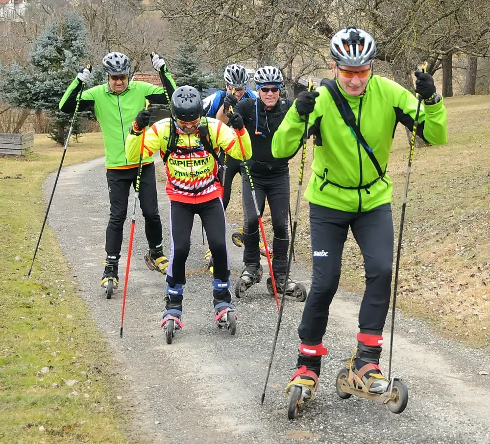 Cross-Skating-Gruppe beim Training bergauf auf einem Schotterweg